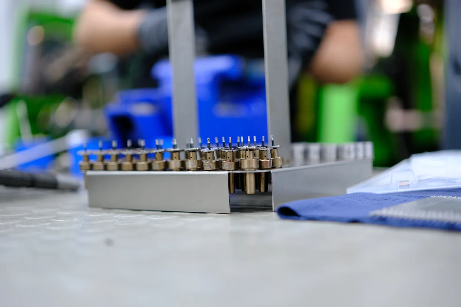 Organized diesel injector components arranged at a production workstation