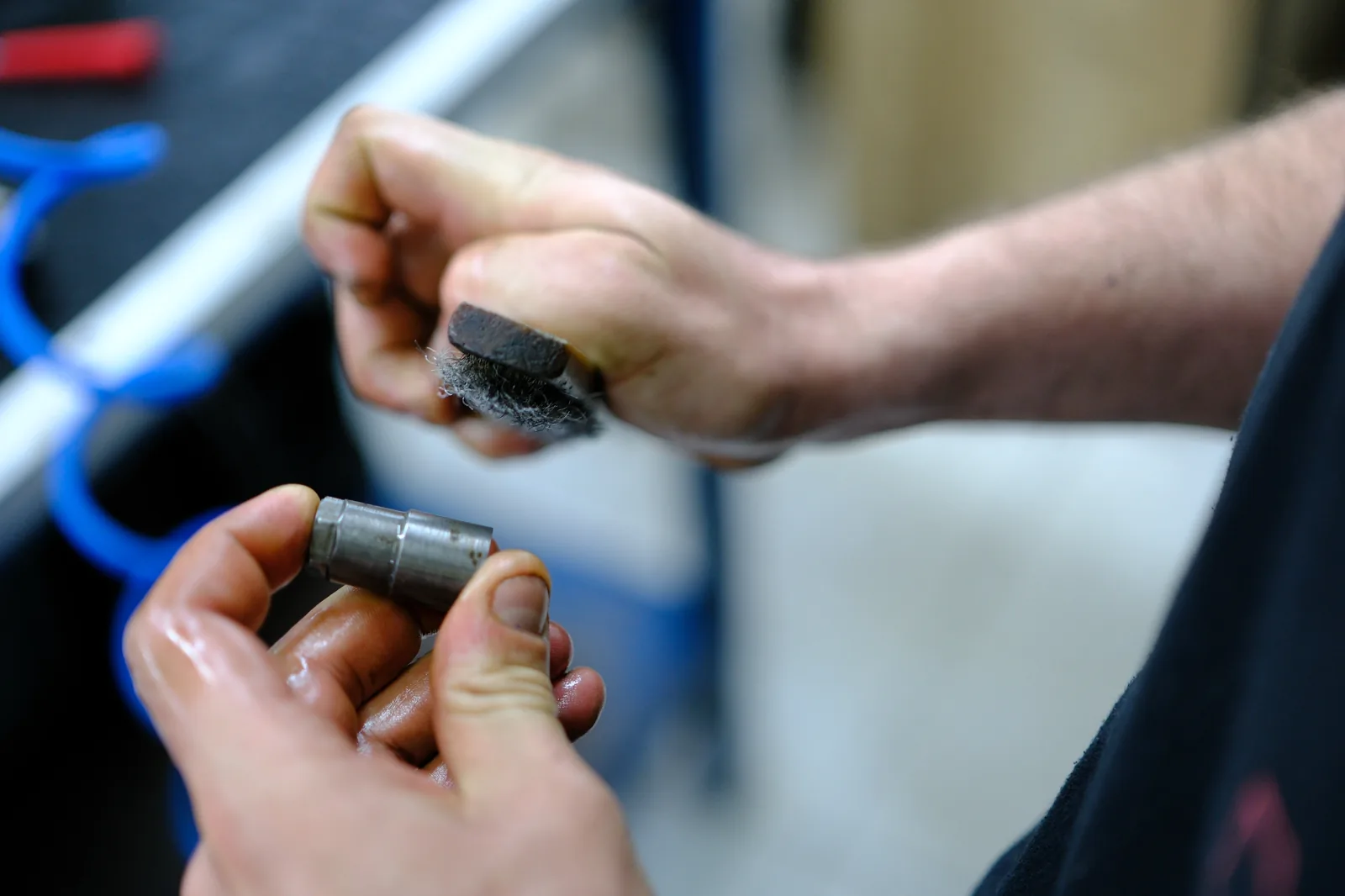 Technician cleaning an internal diesel injector component by hand