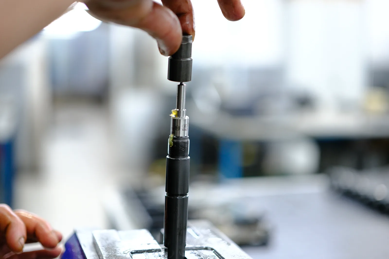 Technician carrying out precision assembly on a diesel injector